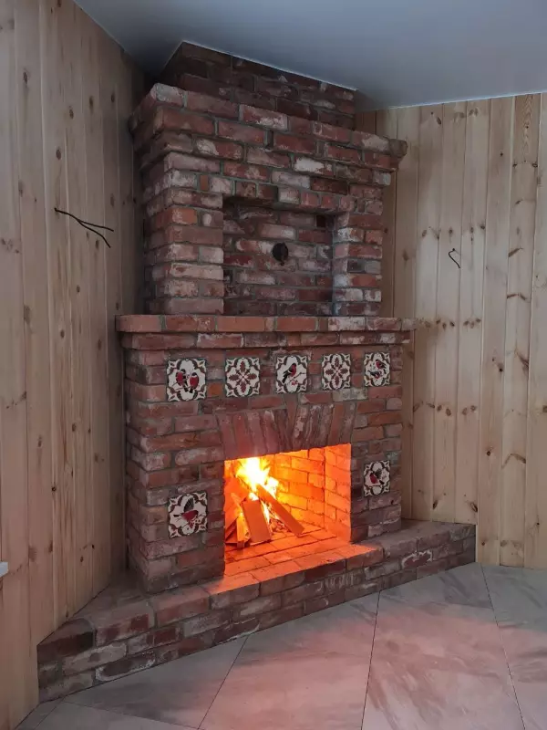 Угловой камин с открытой топкой из старинного кирпича