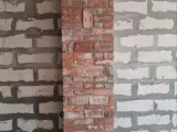 Теплонакопительный камин из старинного кирпича с отделкой дымохода на 2 этаже